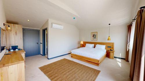 1 dormitorio con 1 cama y TV en una habitación en Unsal Hotel, en Ölüdeniz
