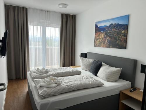 1 dormitorio con 2 camas frente a una ventana en Hotel Casa Maria en Halblech-Buching