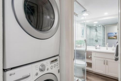 a white washer and dryer in a white bathroom at Kamaole Sands 5-316 in Wailea