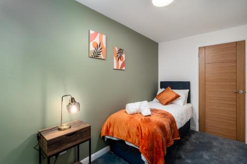 Un dormitorio con una cama con una manta naranja. en The Blue Barbican Flat- spacious, stylish, in a perfect location and accessible, en Plymouth