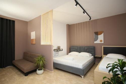 a bedroom with a bed and a chair at TekB Rooms & Apartments in Vlorë