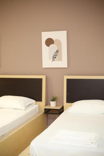 two beds sitting next to each other in a bedroom at TekB Rooms & Apartments in Vlorë