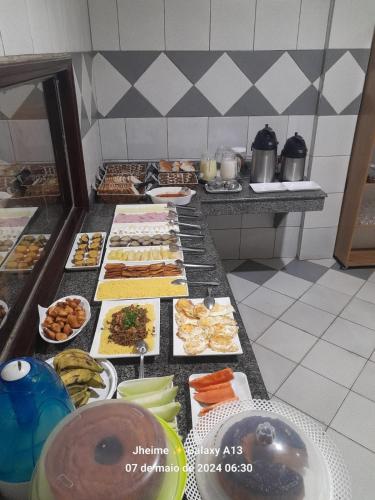 una línea de buffet con muchos tipos diferentes de comida en HOTEL Vitoria Regia, en Brasiléia