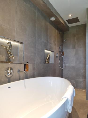 a white bath tub in a bathroom with a shower at Parkhotel Horst - Venlo in Horst