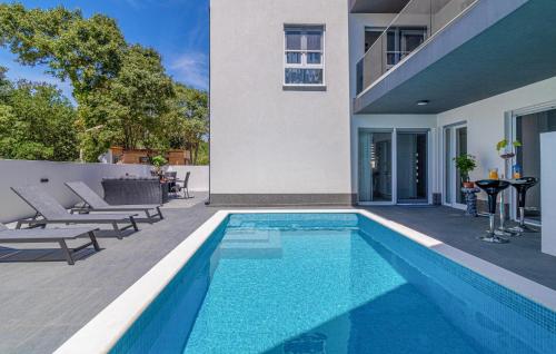 a swimming pool in front of a house at 4 Bedroom Lovely Home In Liznjan in Ližnjan