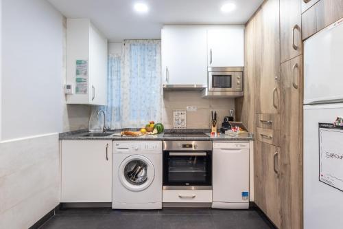a kitchen with white cabinets and a washer and dryer at INSIDE OLD TOWN by Eba Homes in Bilbao