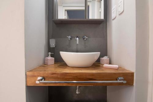 a bathroom with a white sink on a wooden counter at Depto del Bosque, 4 personas, patio, cochera cubierta ,parrilla in Maipú