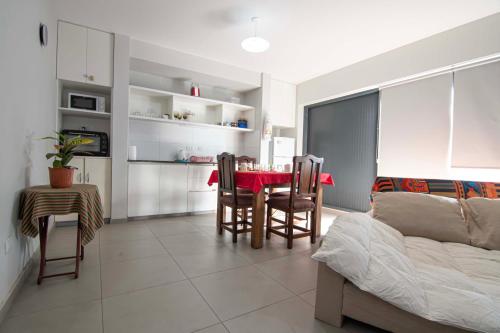 a kitchen and living room with a table and chairs at Depto del Bosque, 4 personas, patio, cochera cubierta ,parrilla in Maipú