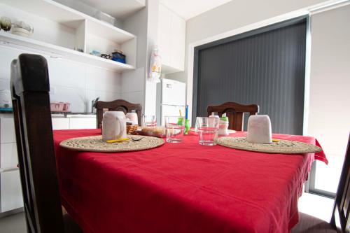a red table with two hats on top of it at Depto del Bosque, 4 personas, patio, cochera cubierta ,parrilla in Maipú