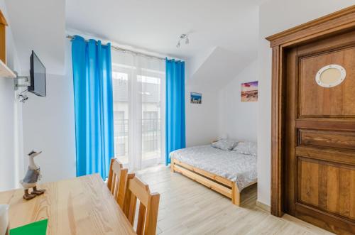 Schlafzimmer mit einem Bett, einem Tisch und einem Fenster in der Unterkunft Willa Artus in Władysławowo