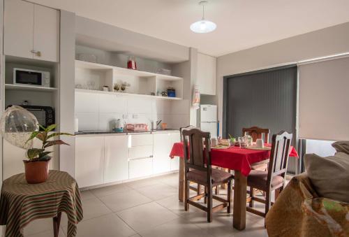 a kitchen and dining room with a table and chairs at Depto del Bosque, 4 personas, patio, cochera cubierta ,parrilla in Maipú