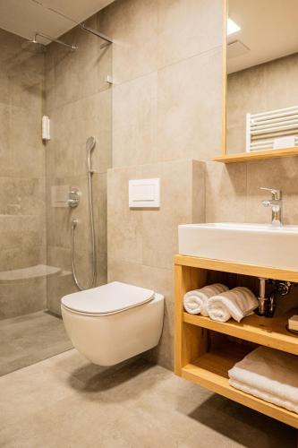 a bathroom with a toilet and a sink and a shower at Lešná Penzion in Zlín