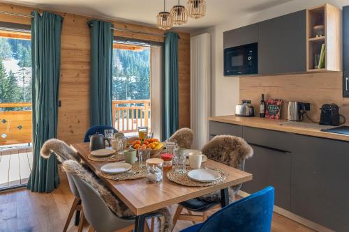 une cuisine et une salle à manger avec une table et des chaises dans l'établissement Apartment Cairn Harmony B104, aux Gets