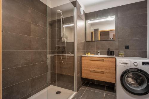 une salle de bain avec douche et machine à laver dans l'établissement Apartment Cairn Harmony B104, aux Gets