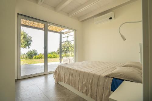 a bedroom with a bed and a large sliding glass door at Alle Preziose Dimore in Tropea