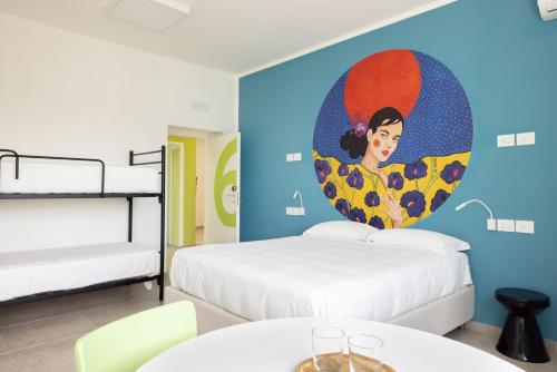 ブリンディジにあるOstello della Gioventù Brindisiのベッドルーム1室(ベッド2台付)が備わります。壁には絵画が飾られています。