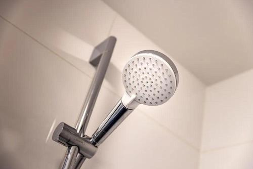 a shower head on a wall in a bathroom at B&k Urban City Suites in Tilburg