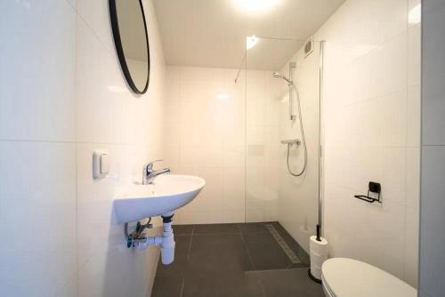 uma casa de banho branca com um lavatório e um WC em B&k Urban City Suites em Tilburg