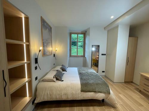 une chambre avec un grand lit et une fenêtre dans l'établissement Tour médiévale rénovée au cœur du Pays du Mont-Blanc, à Sallanches