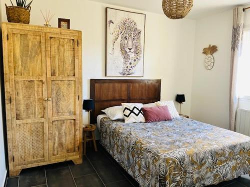 een slaapkamer met een bed en een houten kast bij Villa ALISA avec piscine privée in Roquebrune-sur-Argens
