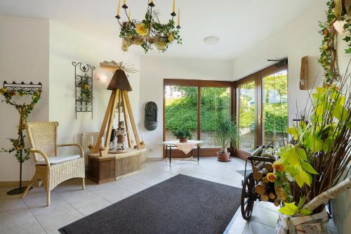 a living room with a chair and a table and windows at Pension Bergblick in Marienberg