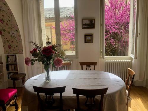 une pièce avec une table avec un vase de fleurs dessus dans l'établissement Appartement de caractère au cœur de Poitiers, à Poitiers