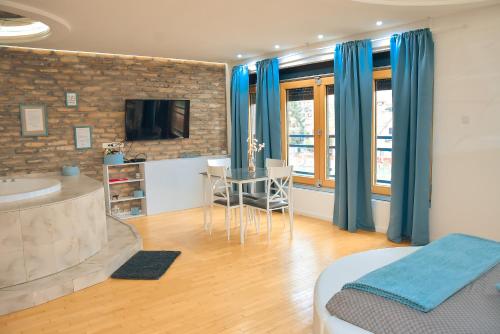 a room with a bed and a television and a table at Hedonist Spa-Avenija in Belgrade