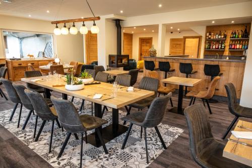 un ristorante con tavoli e sedie e un bar di Logis Le Vernay ad Autrans