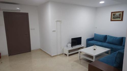 Una sala de estar con un sofá azul y una mesa. en Appartements climatisés JANYA HOLIDAYS, en Alhucemas
