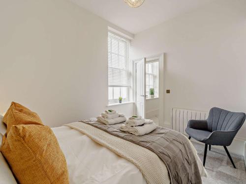 a white bedroom with a bed and a chair at 1 Bed in Carlisle 92869 in Carlisle