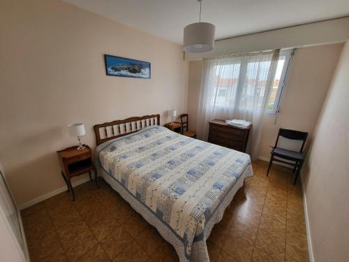 une chambre avec un lit et deux chaises et une fenêtre dans l'établissement T2 avec loggia, parking, à 300m de la plage - FR-1-92-898, à Les Sables-dʼOlonne