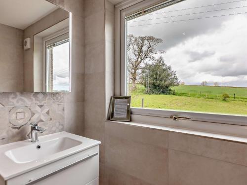 a bathroom with a sink and a window at 3 Bed in Alnwick 93171 in Edlingham