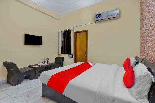 een slaapkamer met een bed, een bureau en een televisie bij OYO Flagship Hotel New A V Hospitality in Chinhat