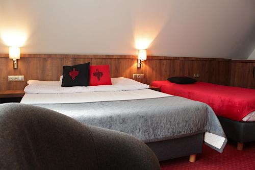 a hotel room with two beds with red pillows at Magnolia in Zakopane