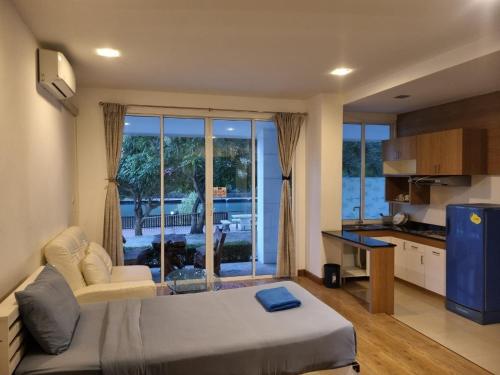 a living room with a large bed and a kitchen at Banchaitalay Room in Rayong