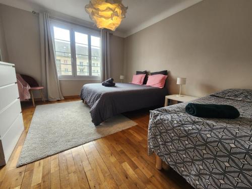 une chambre avec deux lits et une fenêtre dans l'établissement Perle rare - Triangle d'or -98m2 - 6 pers, à Caen