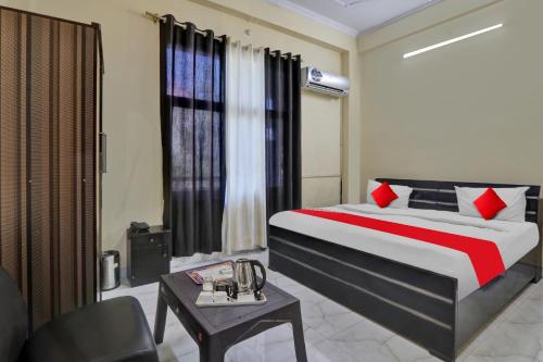 een slaapkamer met een bed, een stoel en een tafel bij OYO Flagship Hotel New A V Hospitality in Chinhat