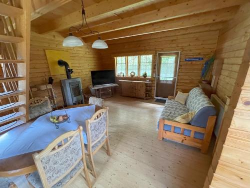 uma sala de estar em cabana de madeira com uma mesa e um sofá em Garten Eden em Frohburg