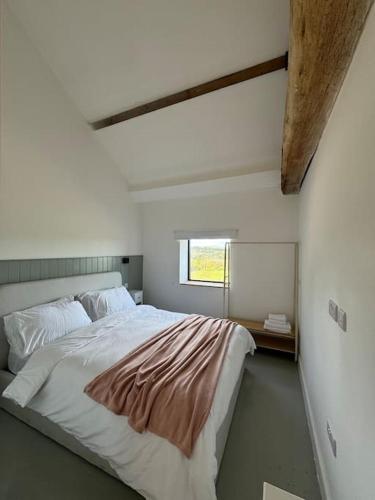 a bedroom with a large bed and a window at The Hayloft, Modern 4 Bed, 8 person, Barn Conversion in a Rural Location with Great Access in Silkstone