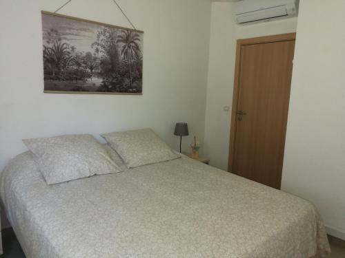 a bedroom with a bed and a picture on the wall at Algajola in Algajola