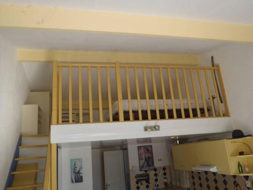 Ce lit superposé se trouve dans un dortoir doté d'un escalier. dans l'établissement REF 4060 Joli studio mezzanine climatisé, à Le Castellas