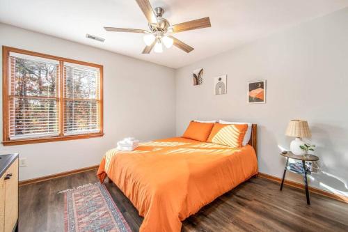 Un dormitorio con una cama y un ventilador de techo. en The Homeplace Abode, en Fayetteville