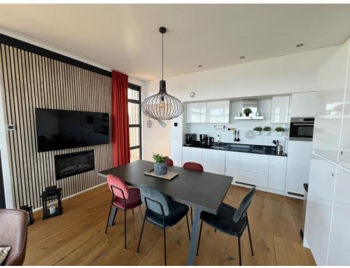 een keuken en eetkamer met een tafel en stoelen bij Strand Chalet am IJsselmeer Haus 214 in Enkhuizen