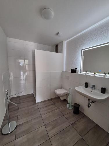 a white bathroom with a sink and a toilet at Ferienwohnung Diemel in Bad Karlshafen