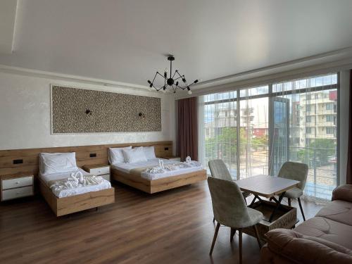 a living room with two beds and a table at Hotel Sunlight in Kobuleti