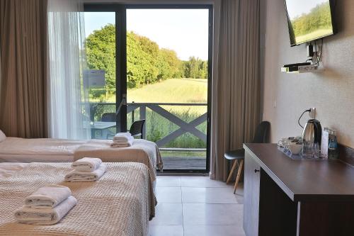 BobrowoにあるPółwysep Wądzyńのベッド2台が備わる窓の景色を望むホテルルームです。
