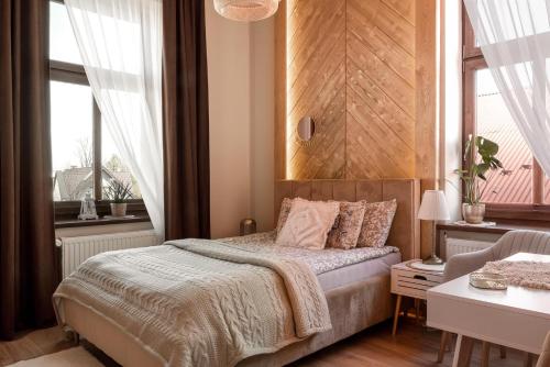 恰魯涅杜納耶茲的住宿－Apartament Złota Perła，一间卧室设有一张床和两个窗户。