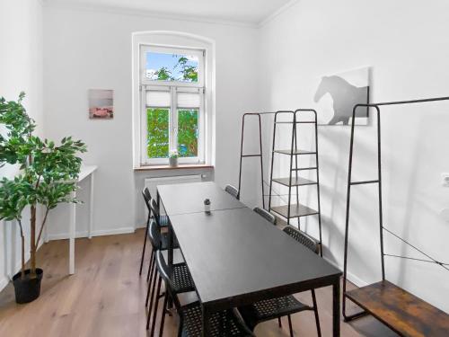 een kamer met een tafel met stoelen en een ladder bij feworld living - Deutsch Wagram bei Wien in Deutsch-Wagram