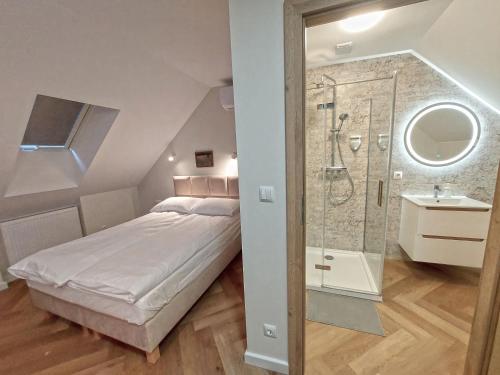 Schlafzimmer mit einem Bett, einer Dusche und einem Waschbecken in der Unterkunft Kwietny Stoczek 70 in Białowieża
