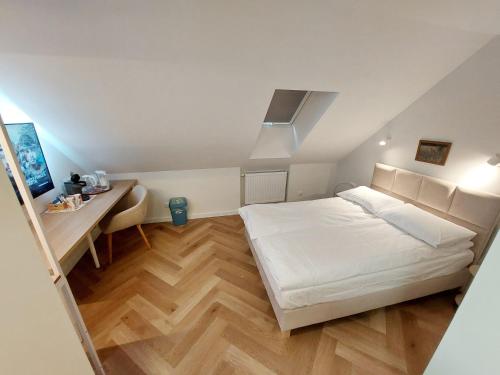 Schlafzimmer mit einem weißen Bett und einem Schreibtisch in der Unterkunft Kwietny Stoczek 70 in Białowieża